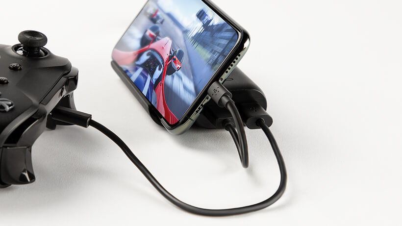 Power Bank charging the smartphone and a game controller simultaneously